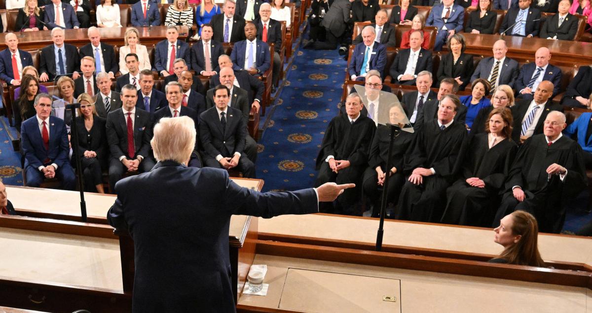 Trump gesturing while speaking to seated members of Congress and Supreme Court justices with his back to the camera