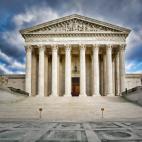 Front of the U.S. Supreme Court building under a dramatic sky with clouds