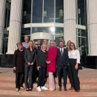A group of people standing on the steps of a courthouse.