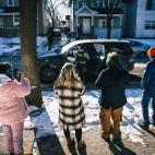 Community members react to Immigration and Customs Enforcement (ICE) agents as they detain a man in Minneapolis, Minnesota. 