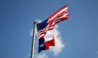 The flags of texas and the United States fly together