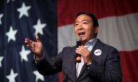 Andrew Yang speaking in front of an American flag