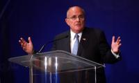 Rudy Giuliani speaking at a podium