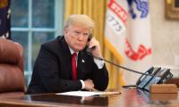 President Donald Trump speaking on the phone in the oval office