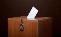 A locked ballot box with a ballot in the top