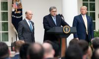 William Barr speaking at a podium