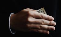 A hand revealing a $20 bill