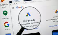 A magnifying glass held over the icon for Google Ads on a computer screen