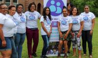 A group of women wearing Free Hearts t-shirts posing in front of a Free Hearts sign