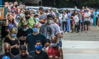 A long line of people in face masks waiting to vote