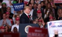 Donald Trump at a podium surrounded by supporters