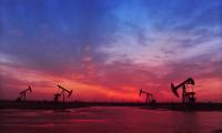 Silhouettes of oil pumps against a sunset