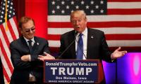 Donald Trump speaking at a podium with Phil Ruffin standing next to him