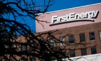 The FirstEnergy logo on the outside of a building with dark branches of a tree in the foreground.