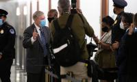 Lindsey Graham wearing a mask and speaking to a group of reporters