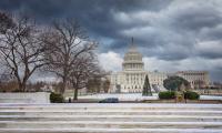 The U.S. Capitol building under dark gray skies.