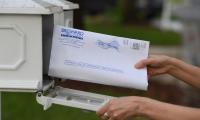 An envelop being put into a mailbox