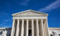 The front of the Supreme Court building against a blue sky