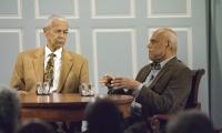 Civil rights activists Bob Moses and Julian Bond sit at a table during a discussion event
