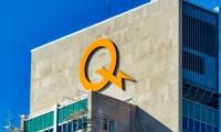 A large yellow "Q" with a lightning bolt on the outside of a building