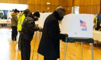 Voters voting at voting booths.