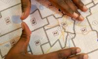 A Black person lays their hands on a congressional district map