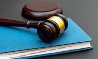 A wooden gavel resting on top of a blue notebook.