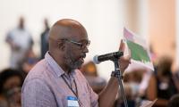 A man speaking at a microphone holding up a map.