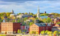 Red brick buildings and a church steeple in Providence, Rhode Island overlooking the water.