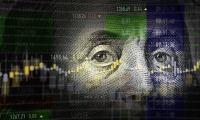 Benjamin Franklin's eyes from a $100 bill overlaid with a stock graph
