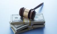 A gavel resting on top of a stack of money