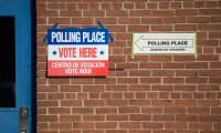 Signs on a brick wall outside a polling place