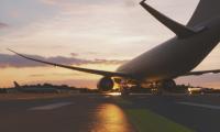 An airplane on a runway at sunset