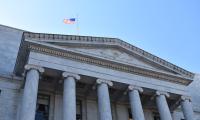 American flag flies above the Rayburn House Office Building.