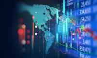 Map of the world on a computer screen overlaid with a stock chart