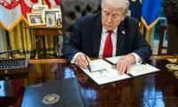 Donald Trump at his desk signing a pardon