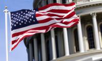 An American flag flying in front of the U.S. Capitol Building