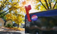 A mailbox with its flag raised and a sticker on it saying "I Voted Today!"