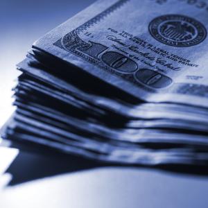 A dimly lit stack of $100 bills