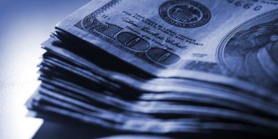 tall stack of cash in dark, gloomy lighting