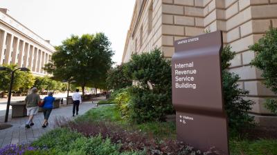 The outside of the Internal Revenue Service building with people walking along the sidewalk