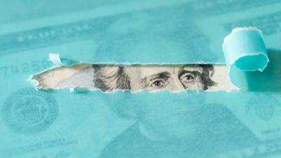 Andrew Jackson on the twenty dollar bill visible through a torn piece of turquoise paper
