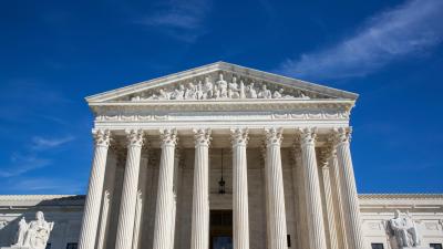 The front of the Supreme Court building against a blue sky