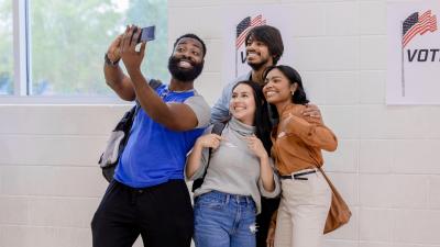 A group of diverse young Americans gather for a selfie photo after voting at their polling place