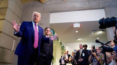 President Trump and Mike Johnson standing in front of a line or reporters with cameras