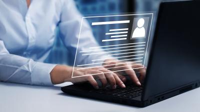 Woman typing on laptop keyboard with overlay graphic of data entry
