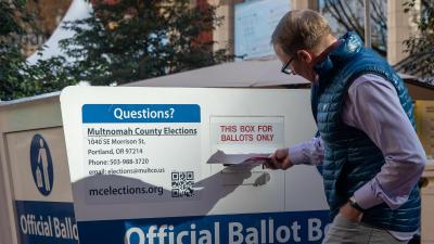 A man places a ballot in a dropbox