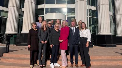 A group of people standing on the steps of a courthouse.