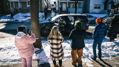 Community members react to Immigration and Customs Enforcement (ICE) agents as they detain a man in Minneapolis, Minnesota. 