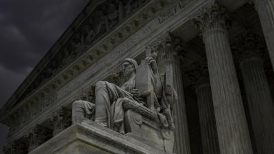 A close-up of one of the statues in front of the U.S. Supreme Court on a cloudy day